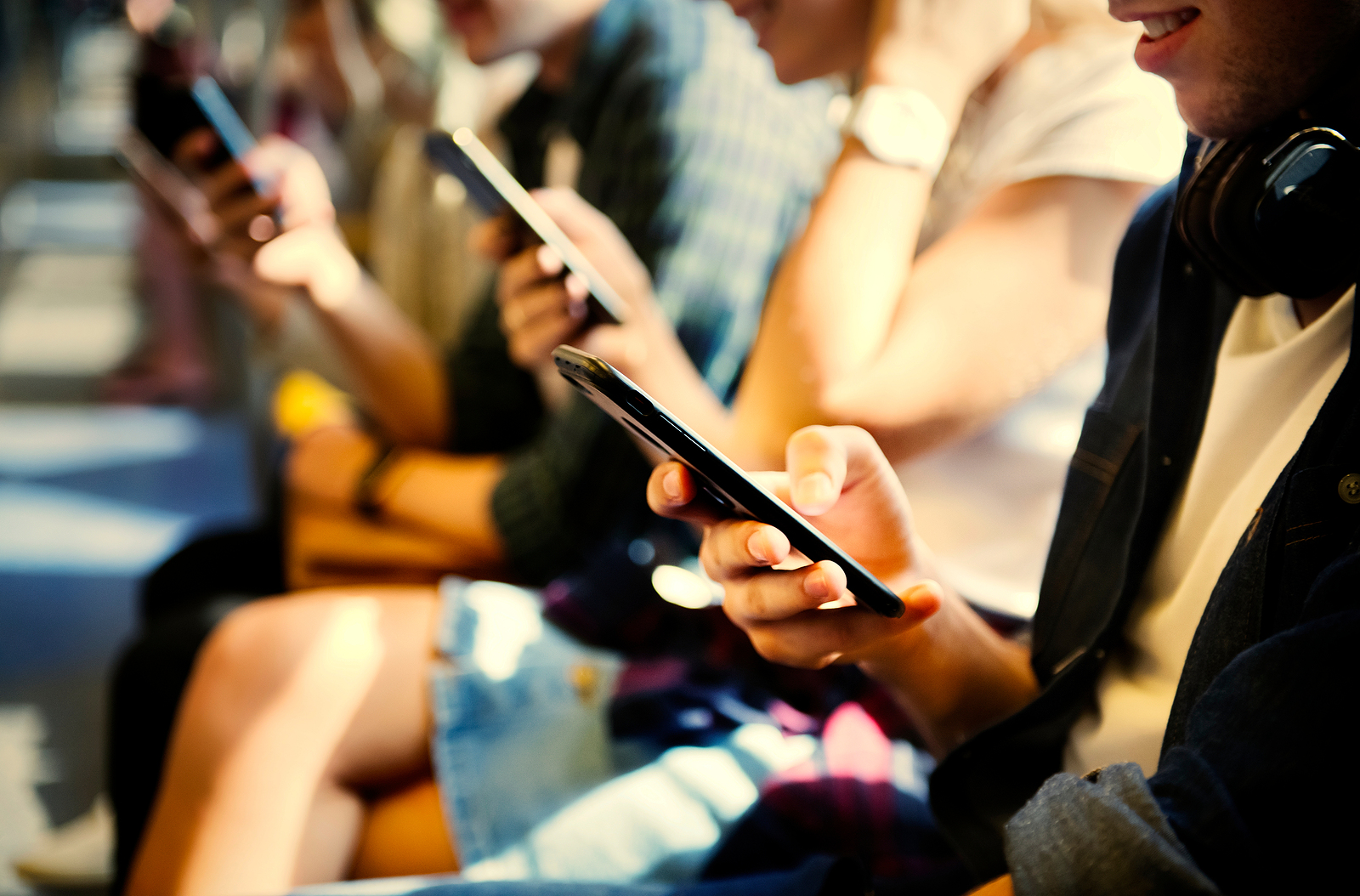 Young people attached to their smartphones. Reading emails and updates