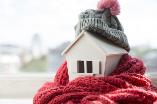 Home for sale in winter. A cute home with a scarf and winter hat. 