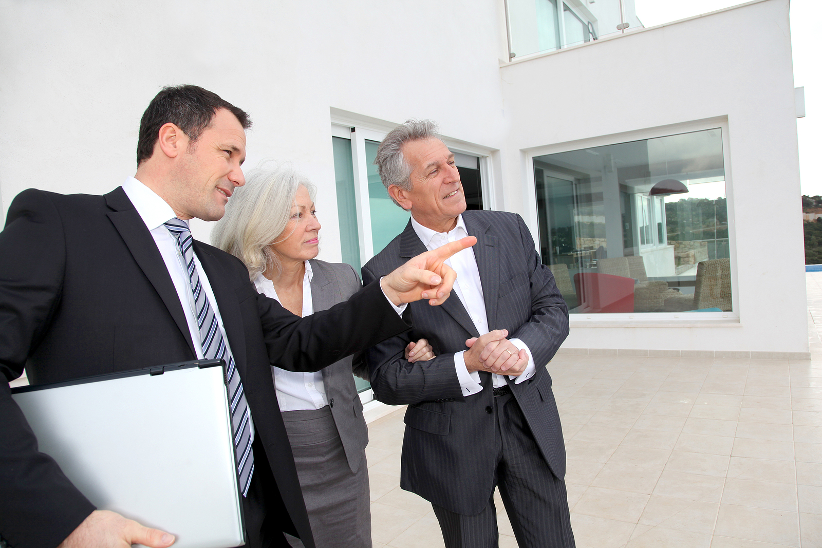 Senior couple visiting luxury villa with real-estate agent